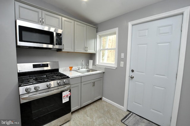 kitchen featuring gray cabinets, sink, and appliances with stainless steel finishes