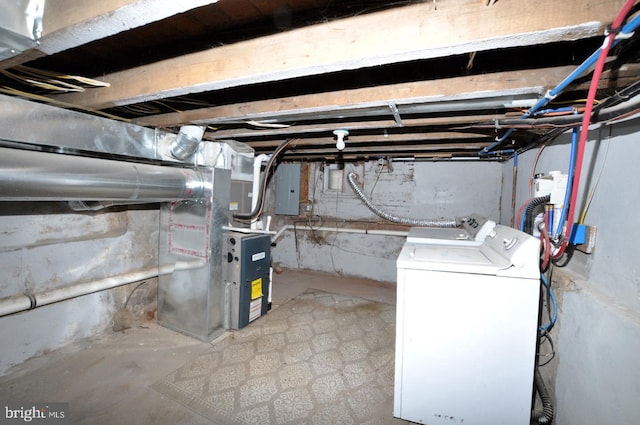 basement with washing machine and clothes dryer, electric panel, sink, and heating unit