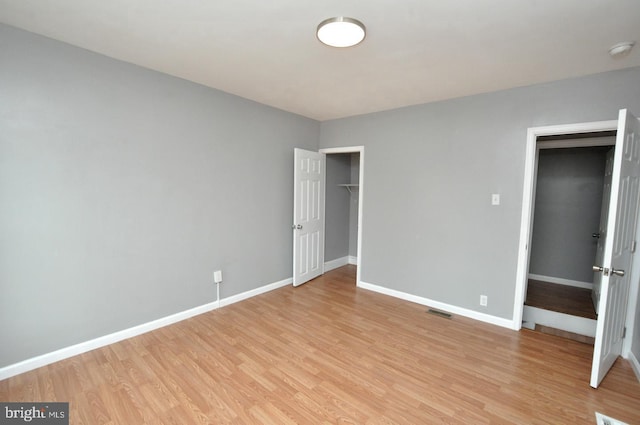 unfurnished bedroom featuring light hardwood / wood-style flooring and a closet