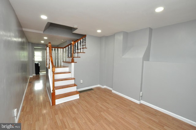 stairs with recessed lighting, wood finished floors, and baseboards