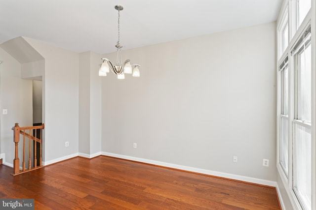 unfurnished room featuring a chandelier and hardwood / wood-style flooring