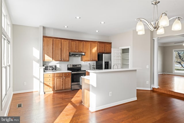 kitchen featuring ceiling fan with notable chandelier, stainless steel appliances, pendant lighting, and plenty of natural light