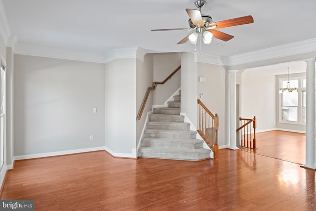 interior space featuring ornamental molding, hardwood / wood-style floors, and ceiling fan with notable chandelier