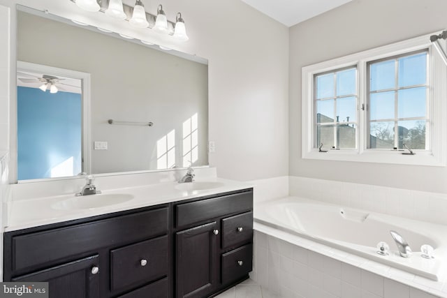 bathroom featuring ceiling fan, vanity, and a relaxing tiled tub