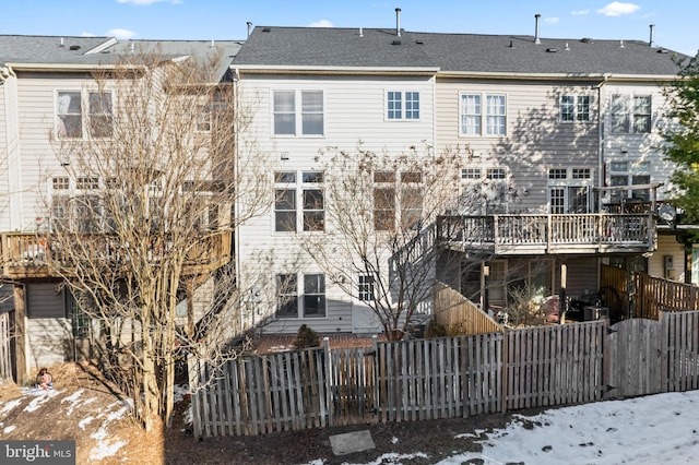 view of snow covered back of property