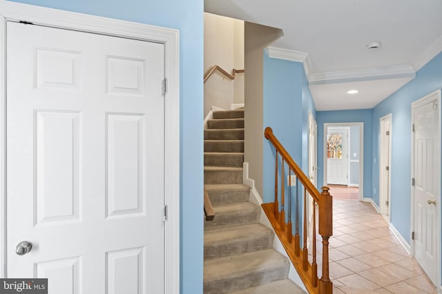 staircase with crown molding and tile patterned floors