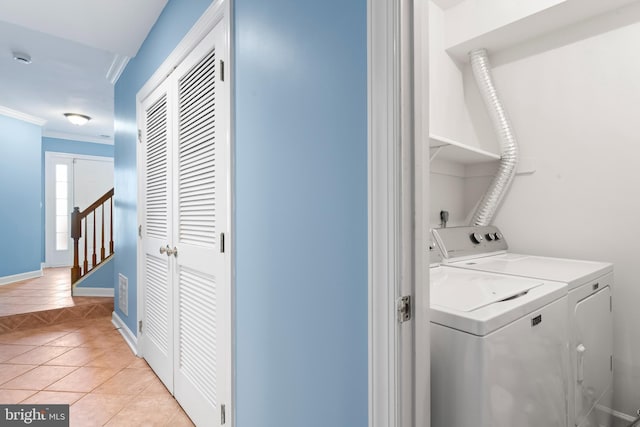 laundry room with washer and dryer, light tile patterned floors, and crown molding