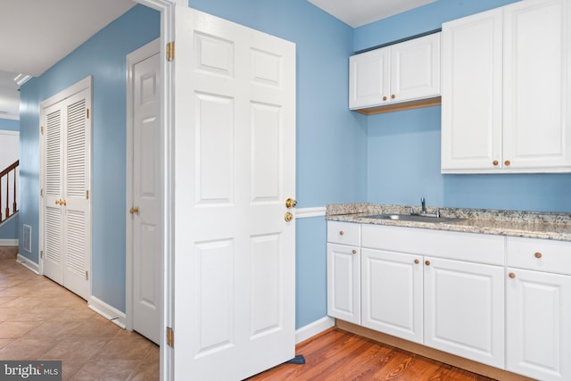 laundry room featuring sink and light wood-type flooring