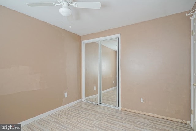 unfurnished bedroom with ceiling fan and a closet