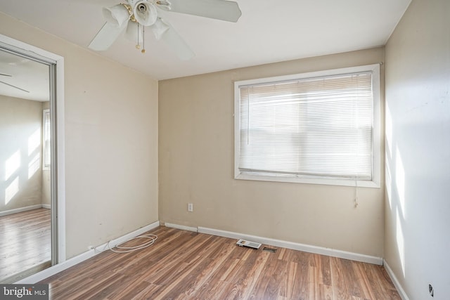 unfurnished room featuring ceiling fan, a healthy amount of sunlight, and hardwood / wood-style floors