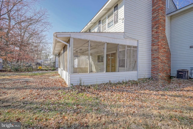 view of side of home with a sunroom and central AC unit