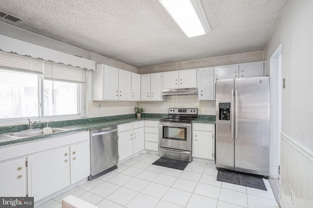 kitchen with sink, a textured ceiling, white cabinets, and stainless steel appliances