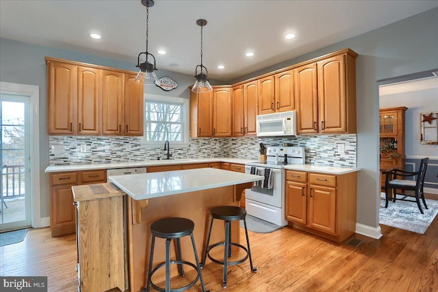 kitchen featuring white appliances, a center island, and a healthy amount of sunlight