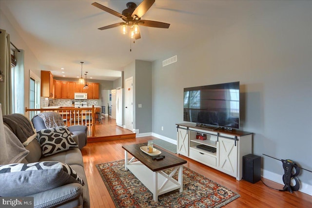 living room featuring light hardwood / wood-style flooring and ceiling fan