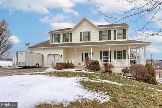 view of front facade featuring a porch, a garage, and a lawn