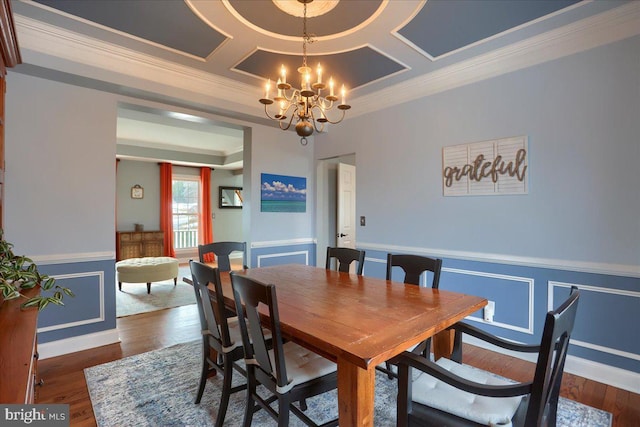 dining space with crown molding, coffered ceiling, dark hardwood / wood-style floors, and a notable chandelier