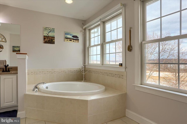 bathroom with tile patterned flooring, vanity, and a relaxing tiled tub