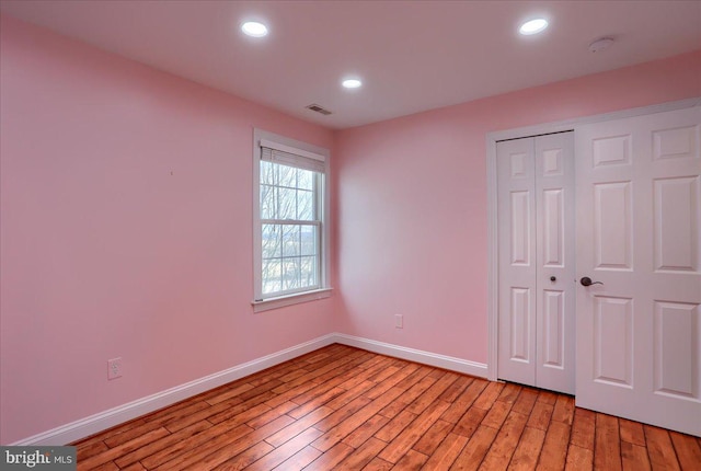 unfurnished bedroom featuring light hardwood / wood-style flooring and a closet