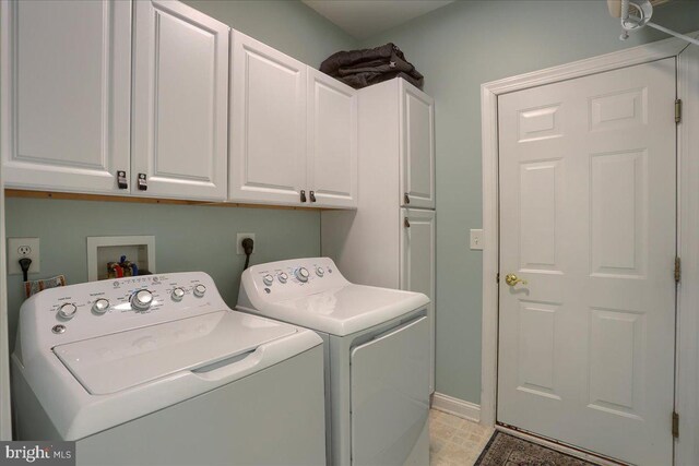 washroom with cabinets and washing machine and dryer