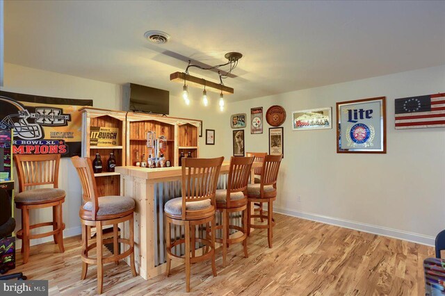 bar with hardwood / wood-style floors