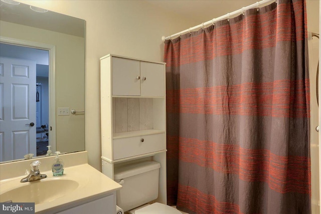 bathroom featuring vanity, toilet, and curtained shower