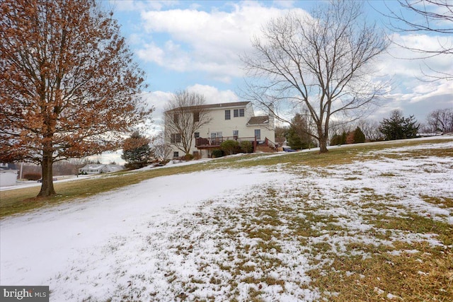 snowy yard featuring a wooden deck