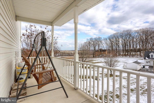 view of snow covered back of property