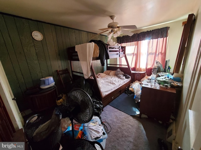 bedroom featuring carpet flooring, ceiling fan, and wood walls