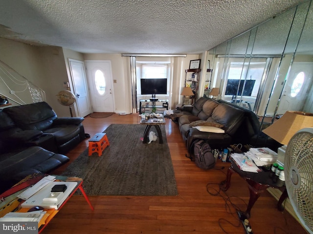 living room with hardwood / wood-style floors and a textured ceiling