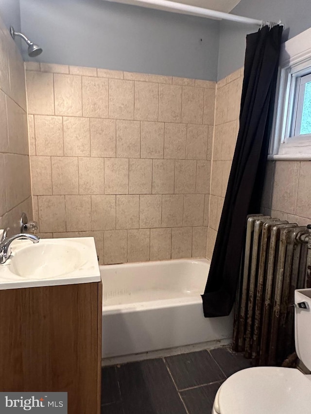 full bathroom featuring toilet, radiator heating unit, shower / bath combo, and sink