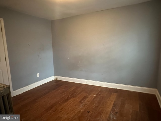 unfurnished room with dark hardwood / wood-style flooring