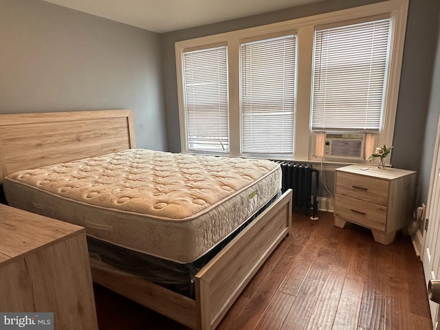 bedroom featuring radiator, dark hardwood / wood-style flooring, and cooling unit