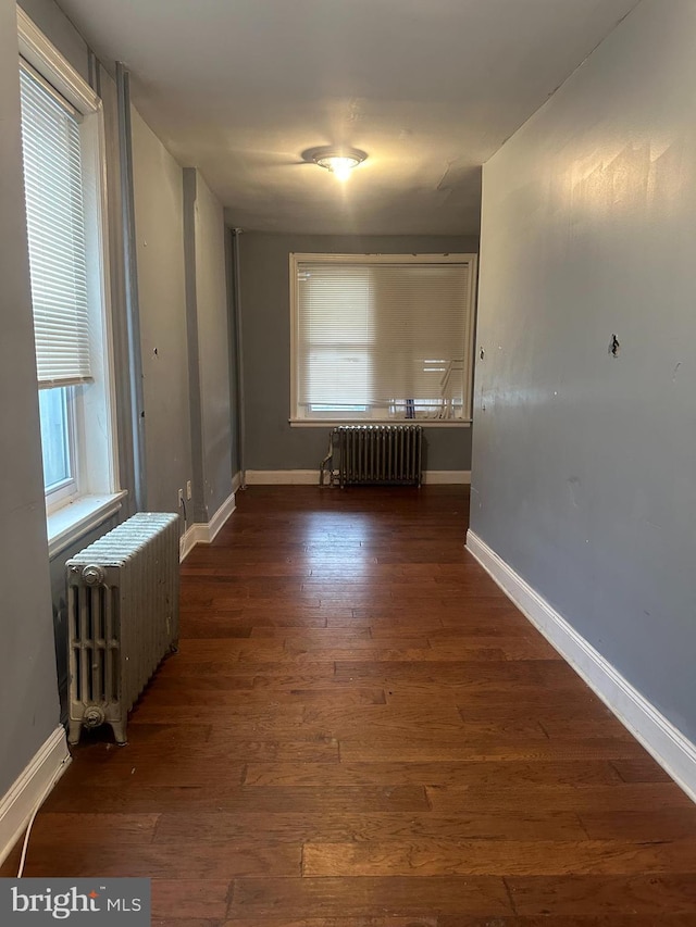 interior space with dark hardwood / wood-style floors and radiator heating unit