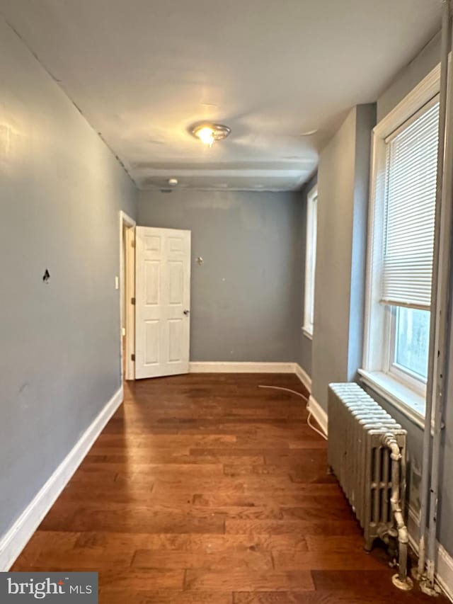 hallway with dark hardwood / wood-style floors and radiator