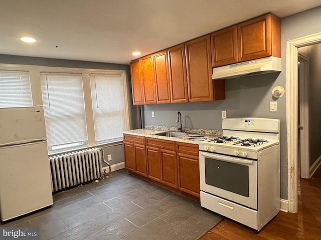 kitchen with radiator, sink, and white appliances