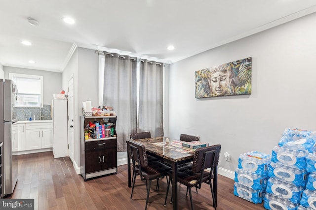 dining room with dark hardwood / wood-style flooring and crown molding