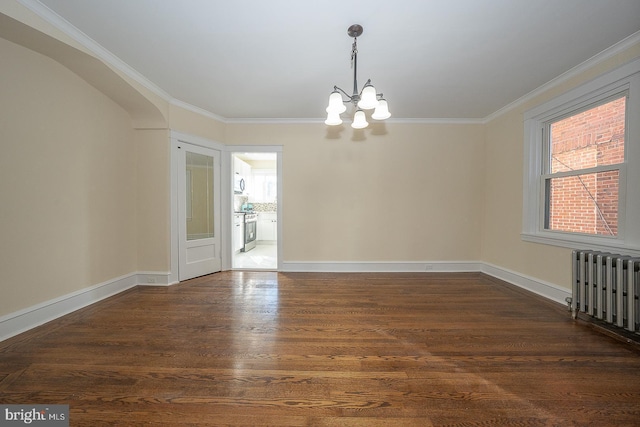 unfurnished room with dark hardwood / wood-style floors, radiator heating unit, crown molding, and an inviting chandelier