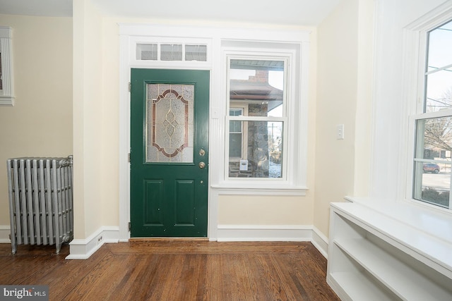 entryway with dark hardwood / wood-style flooring and radiator heating unit