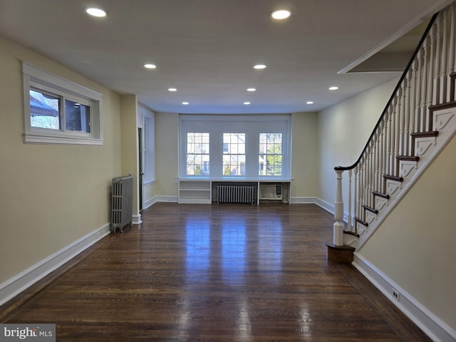 unfurnished living room featuring radiator heating unit and dark hardwood / wood-style floors