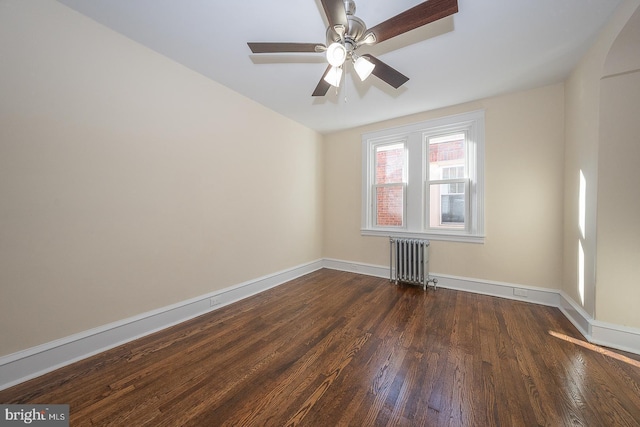 empty room with radiator, ceiling fan, and dark hardwood / wood-style flooring