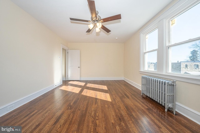 spare room featuring radiator heating unit, dark hardwood / wood-style floors, and ceiling fan