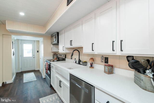 kitchen featuring sink, white cabinets, dark wood-type flooring, and appliances with stainless steel finishes