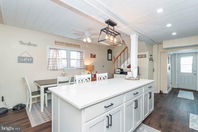 kitchen featuring pendant lighting, a center island, dark hardwood / wood-style floors, a wealth of natural light, and white cabinetry