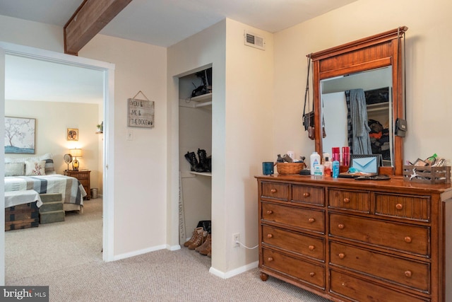 carpeted bedroom with beamed ceiling