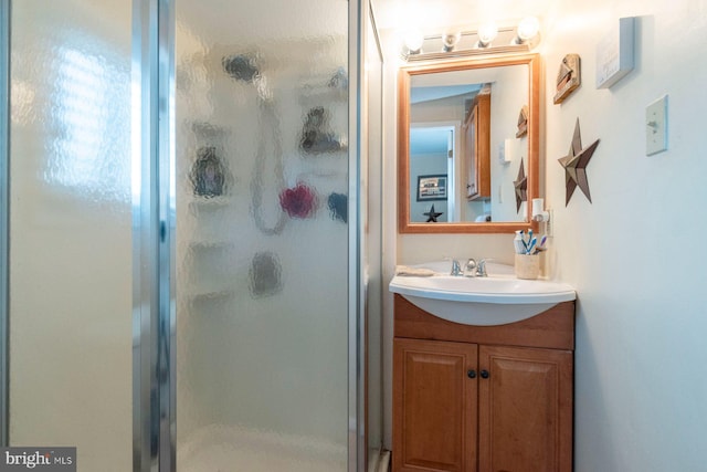 bathroom with vanity and a shower with door