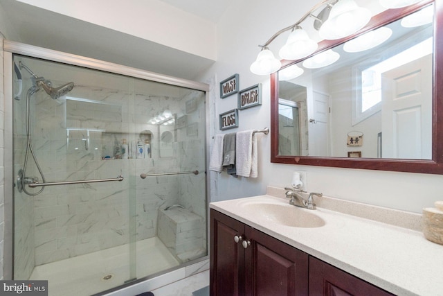 bathroom featuring vanity and a shower with door