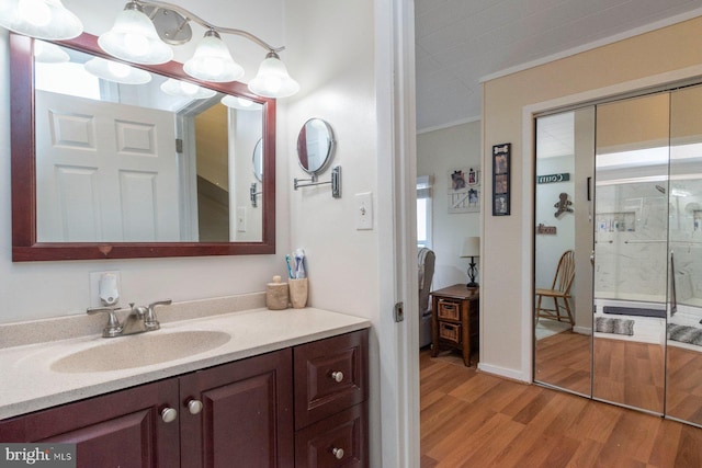 bathroom with hardwood / wood-style floors, vanity, and walk in shower