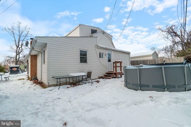 view of snow covered back of property