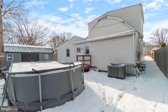 snow covered property with central air condition unit