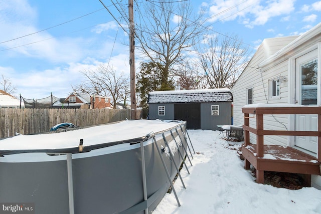 snowy yard featuring cooling unit and a storage shed